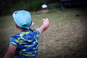 An image of a kid throwing a bocce ball